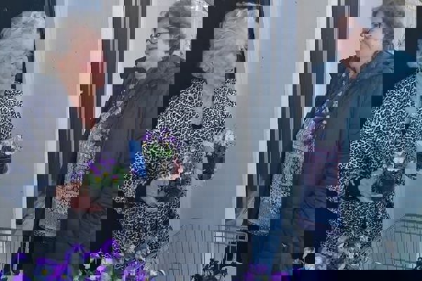 Twee vrouwen hebben viooltjes vast. 