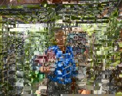 Vrouw staat in tuin.