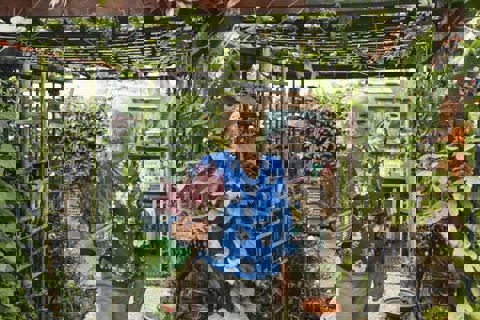 Vrouw staat in tuin.