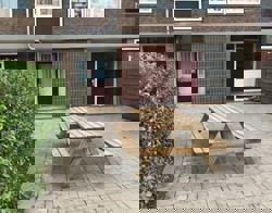 Achtertuin met picknick bank.