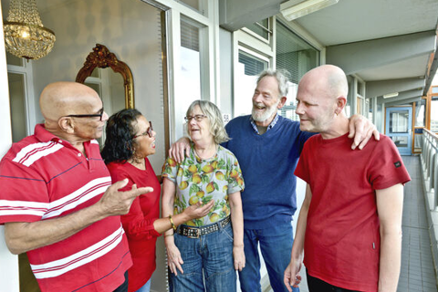 Vijf bewoners staan naast elkaar en lachen. 