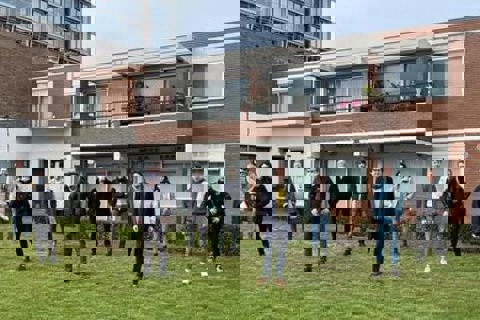 Groep mensen staan op de nieuwe toekomstige moestuin. 