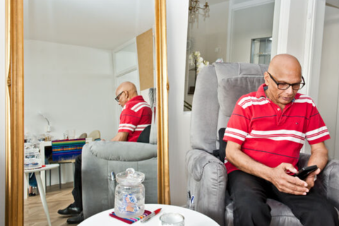 Bewoner zit op telefoon.