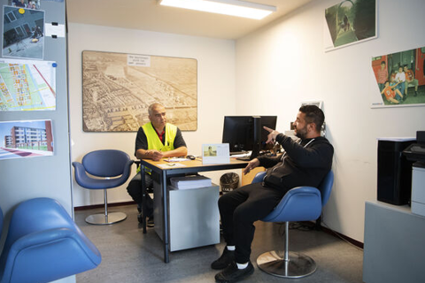 Twee mensen zitten aan een bureau. 
