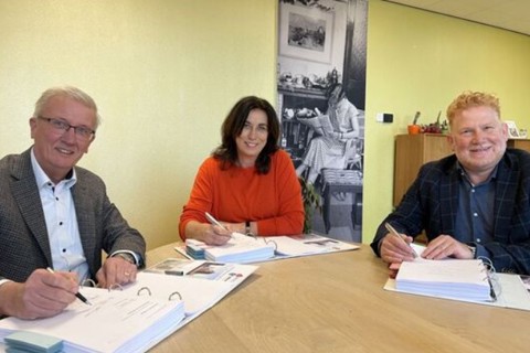 Contractondertekening met drie personen. 