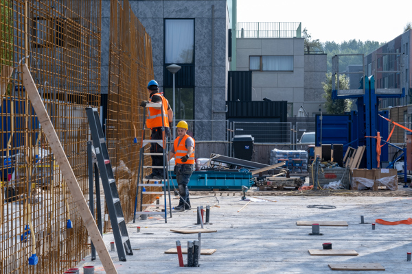 Twee bouwvakkers bezig op bouwterrein