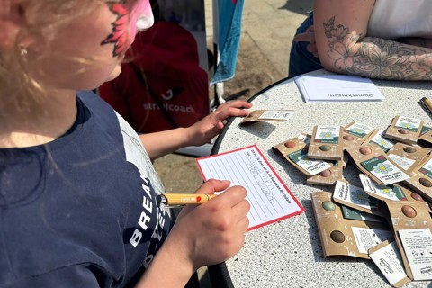 Kind vult kaart in bij een koffiekar bijeenkomst