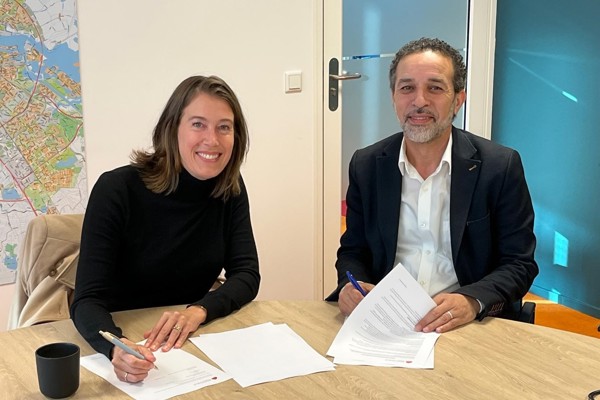 Corinne Ellemeet en Mohamed Acharki zitten aan tafel tijdens ondertekening