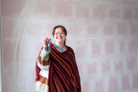 Lachende bewoner houdt sleutel vast