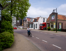 Foto van man op fiets in een afbuigende weg