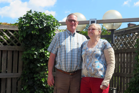 Twee bewoners staan voor schutting en lachen
