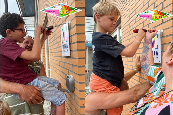Kinderen schroeven een bordje op de muur