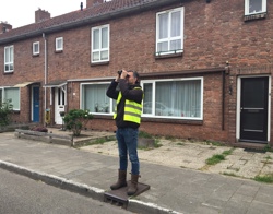 Man op straat kijkt door verrekijker