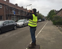 Man op straat kijkt door verrekijker