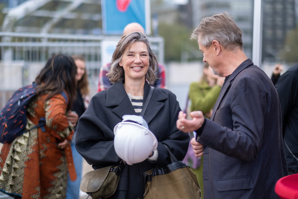 Vrouw kijkt lachend naar de camera