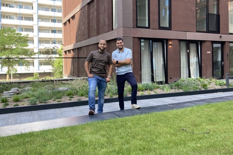 Imad en Hicham van Stichting IMD poseren voor gebouw van Ottho