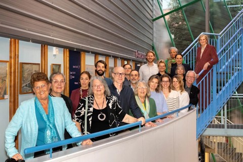 Groep betrokken mensen prestatieafspraken diemen poseren op een blauwe trap