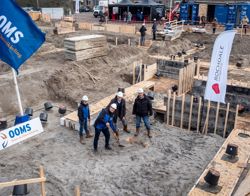 Drie mannen die een tijdcapsule begraven op een bouwplaats.