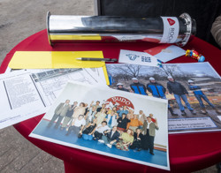 Verschillende foto's, tekeningen en kaartjes op een tafel.