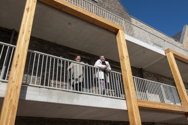 Een nieuwe bewoner en haar moeder op een houten galerij